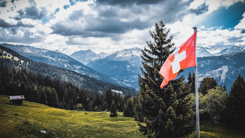 Schweizer Berge mit einer Schweizer Flagge im Vordergrund